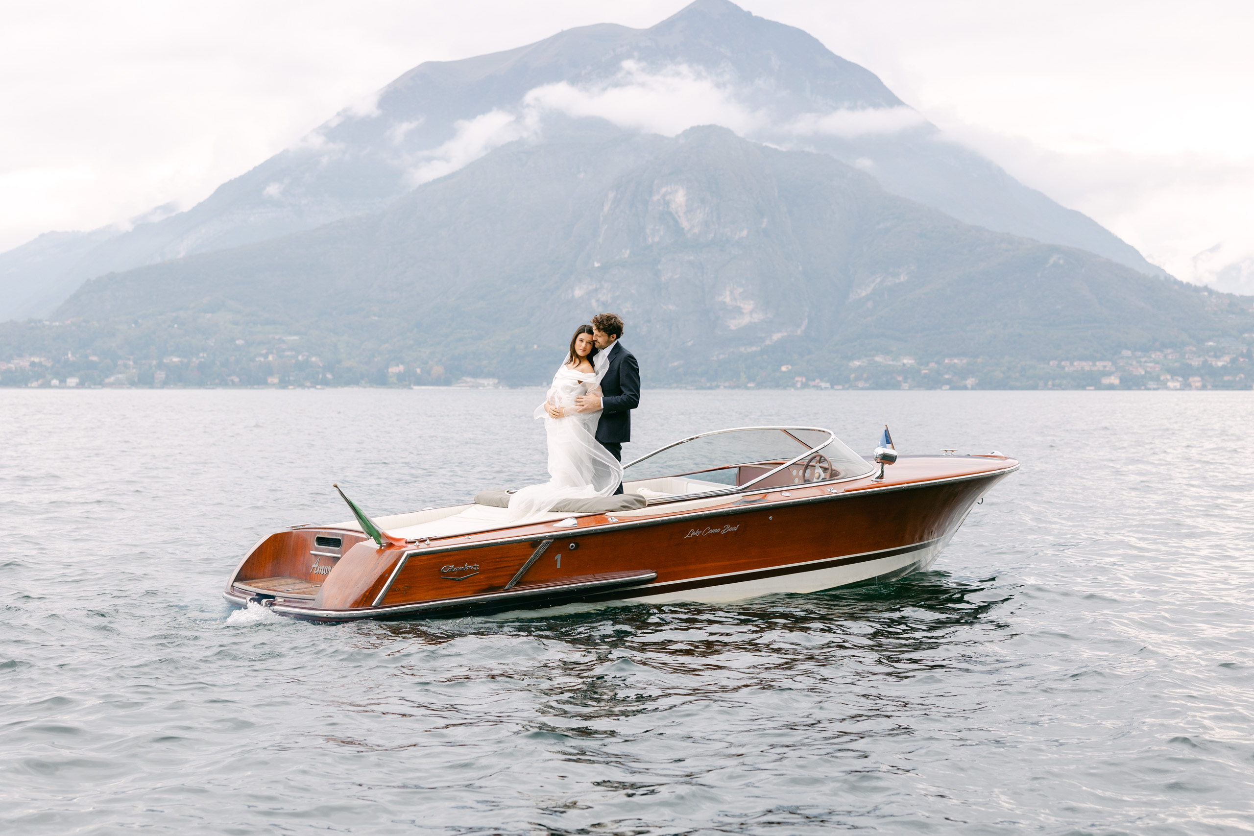 Bride and groom aboard a classic wooden boat during a luxury Lake Como wedding inspiration in Italy.